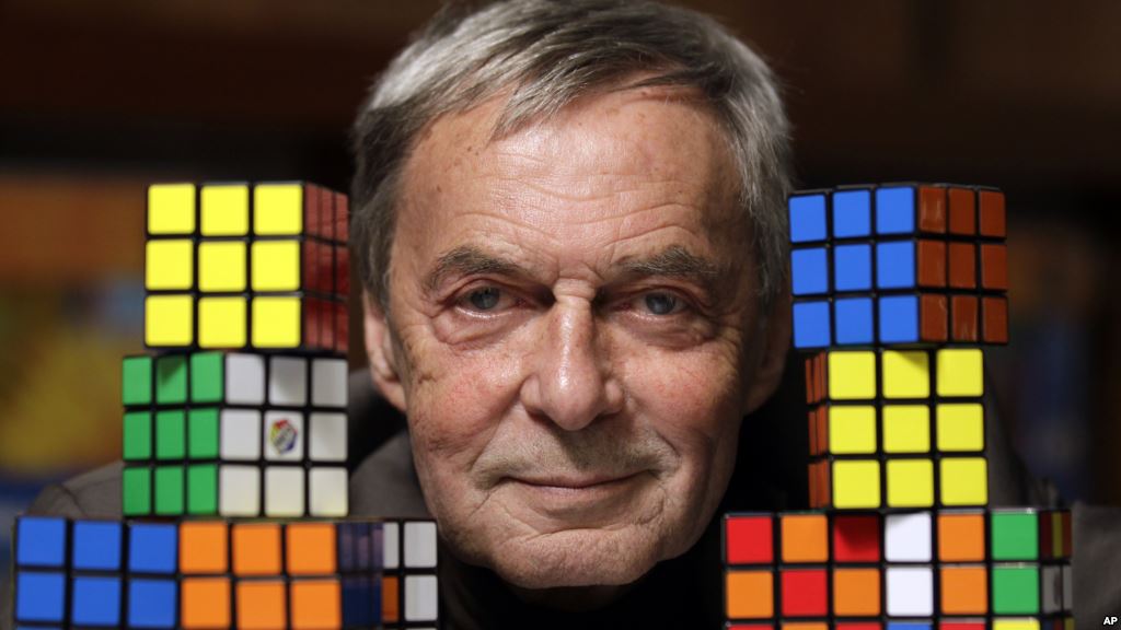 ernõ rubik com duas pilhas de cubo mágico