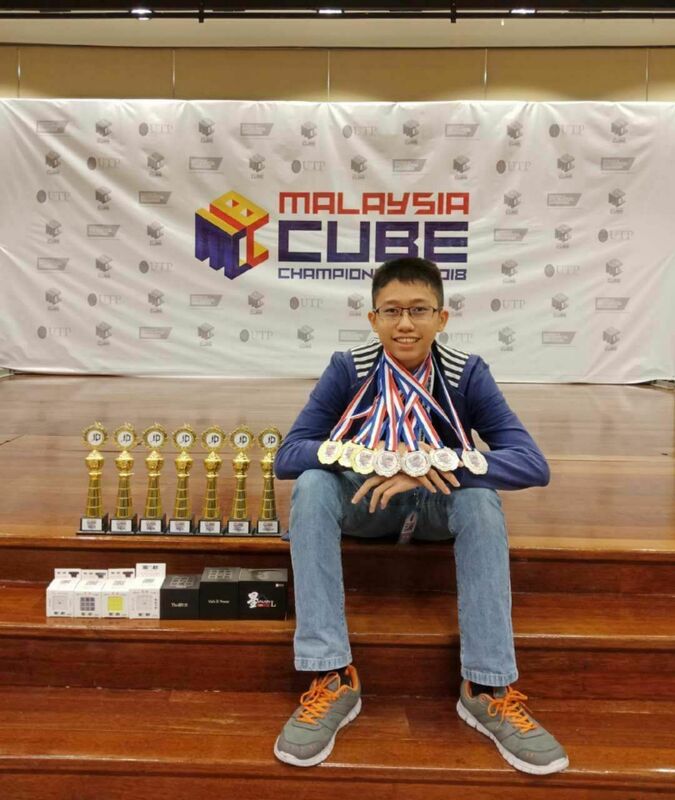 Imagem do competidor Hill Pong Yong Feng com várias medalhas no Malaysia Cube Championship, competidor responsável por conquistar recorde mundial do cubo 5x5x5 vendado no maior torneiro de cubo mágico do mundo 