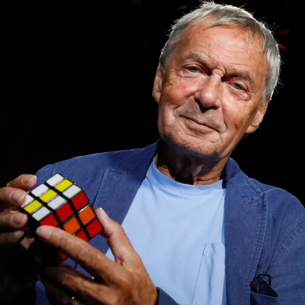 Imagem de Ernõ Rubik, criador do cubo mágico, segurando um cubo 3x3x3 