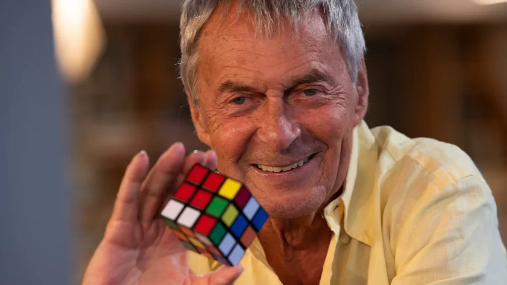 Imagem de Ernõ Rubik, criador do cubo mágico ,segurando um cubo 3x3x3