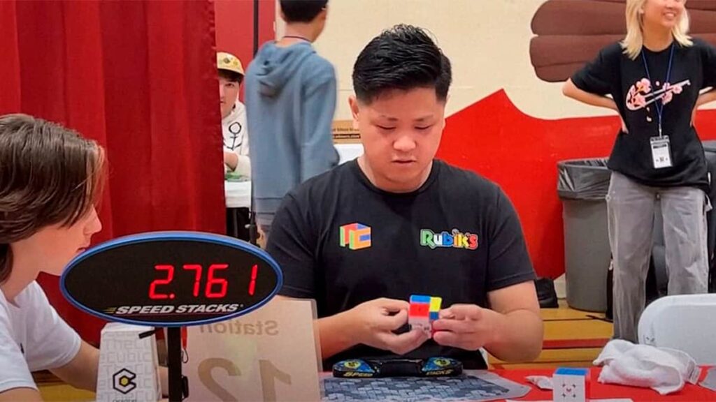 Imagem do speedcuber Max Park resolvendo um cubo mágico durante uma competição