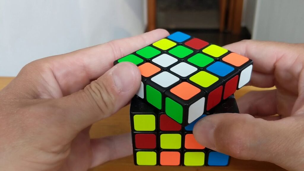 Imagem de uma mão resolvendo o cubo 4x4x4
