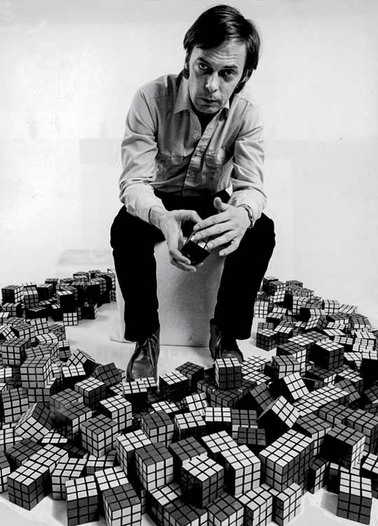 Imagem de Ernõ Rubik com uma coleção do cubo 3x3x3